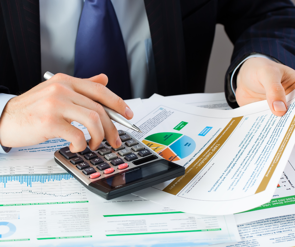 Un professionnel utilisant une calculatrice et des documents financiers, représentant un cabinet comptable paris.