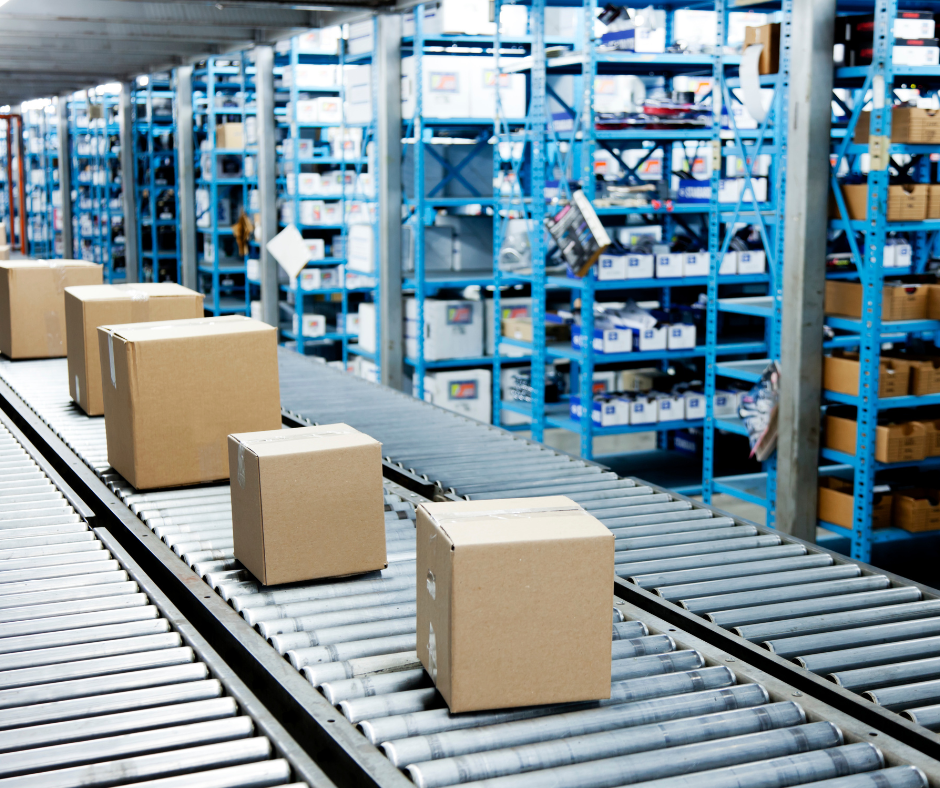 Convoyeur à bandes transportant des cartons dans un entrepôt avec des étagères de stockage en arrière-plan